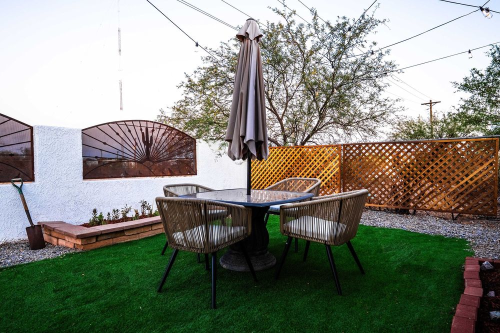 Five panoramic photos showing a grassy backyard space with brown fencing and outdoor furniture in different angles.