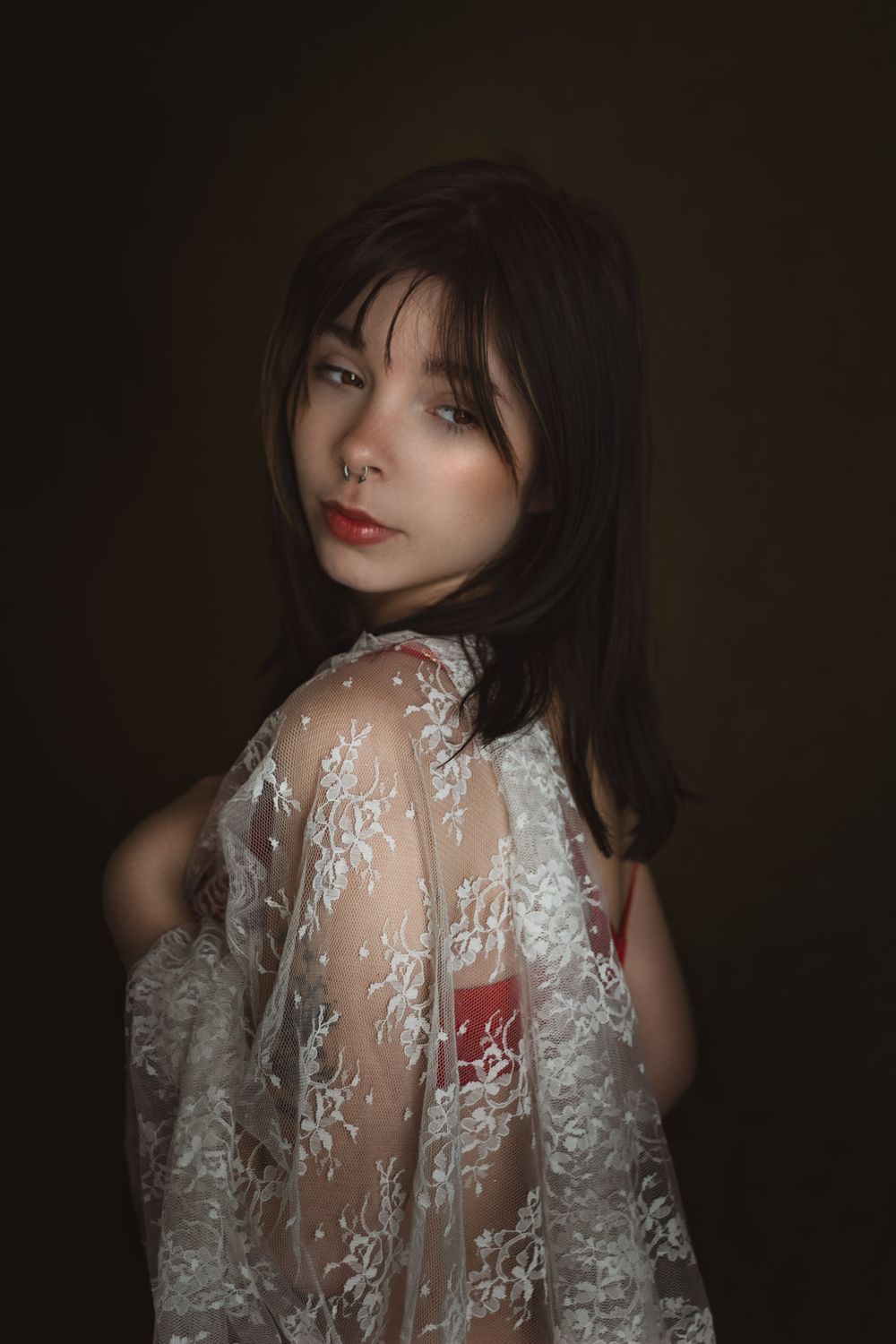Woman draped in white lace during a boudoir studio photo session in Joplin, Missouri.