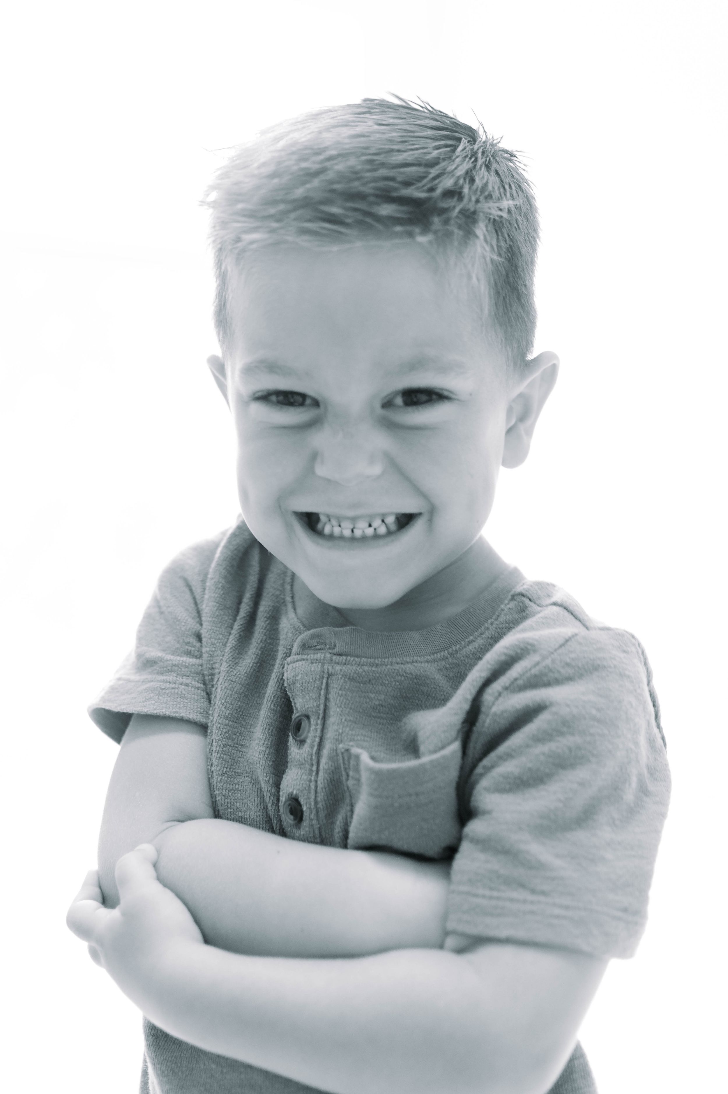 Series of black and white images showing a young child making silly expressions and poses.