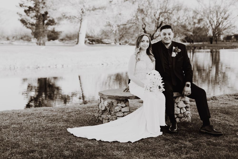 Black and white wedding photography series showing romantic moments by a pond in a rustic outdoor setting.