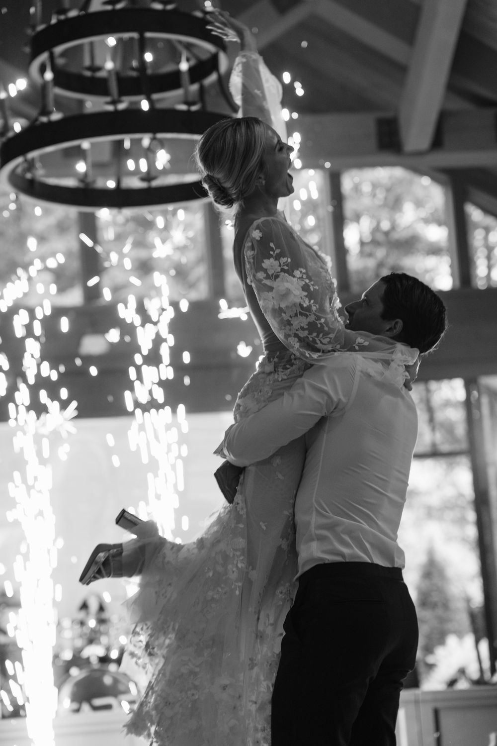 A couple dances together in a romantic embrace under sparkling lights bride and groom old edwards inn north carolina
