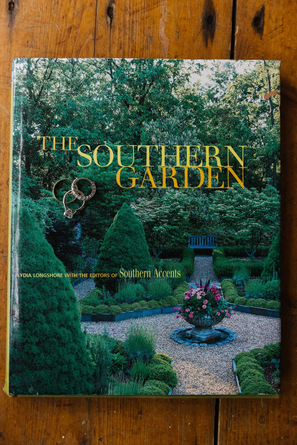 Three book covers about Southern gardens displayed on a wooden surface with lush green garden photos.