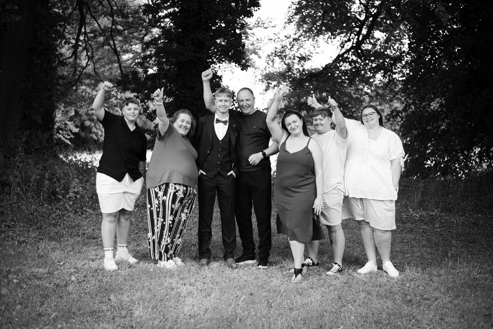 A black and white group photo of people gathered outdoors in a casual setting.