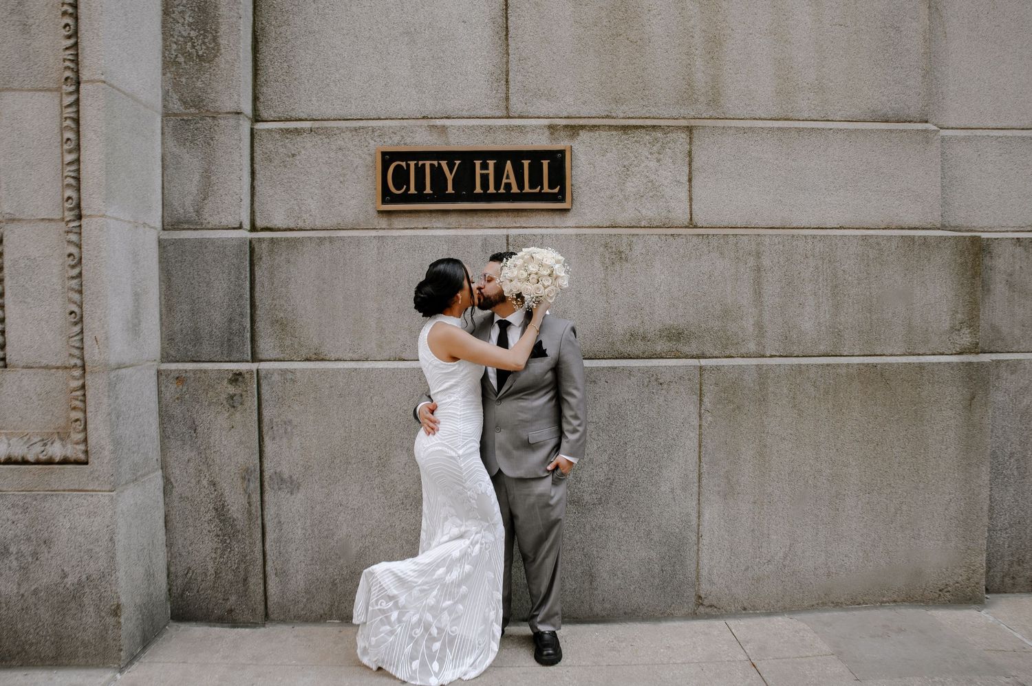 Two people embrace warmly in front of an American flag during a formal event.