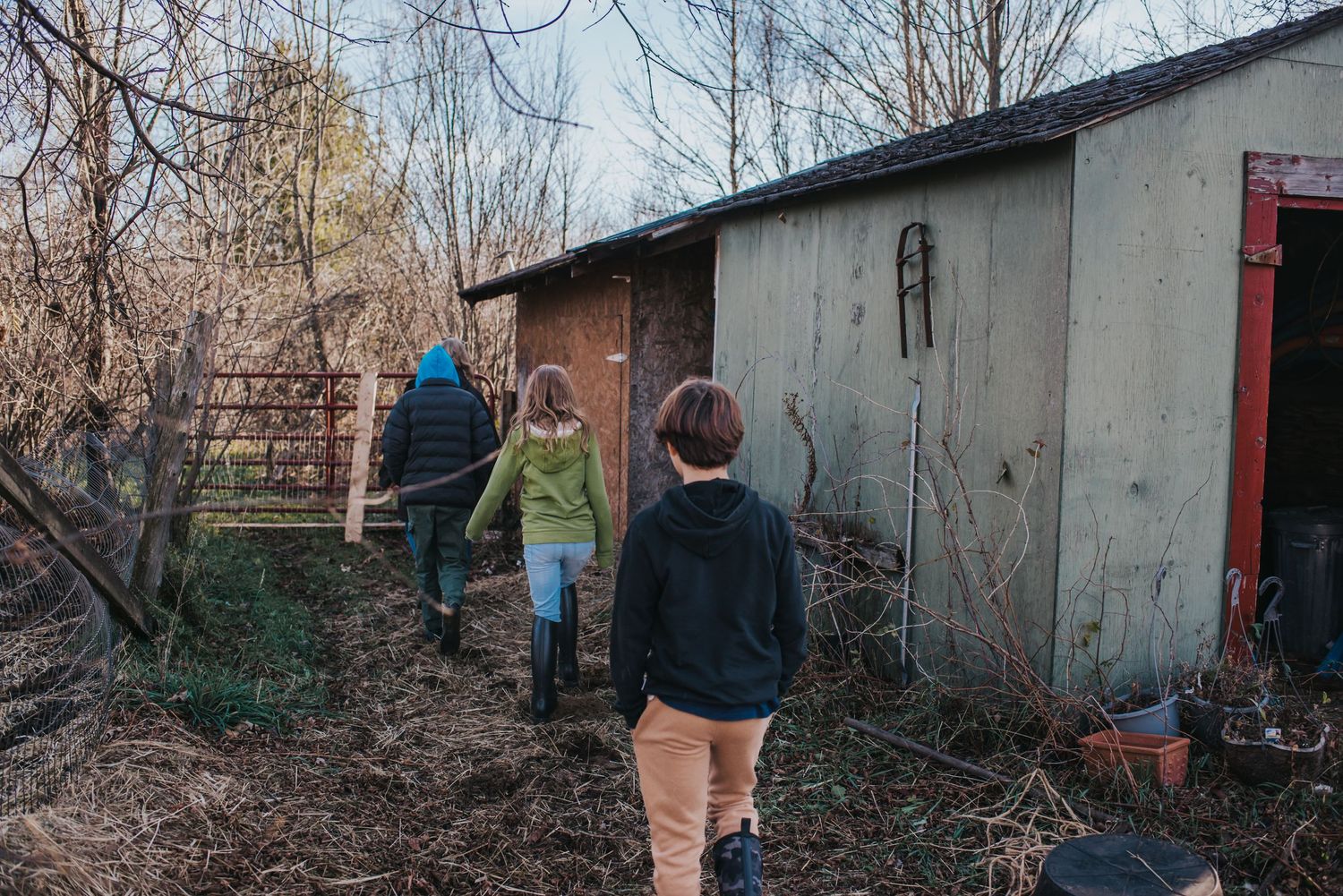 3 kids walk toward a shed.