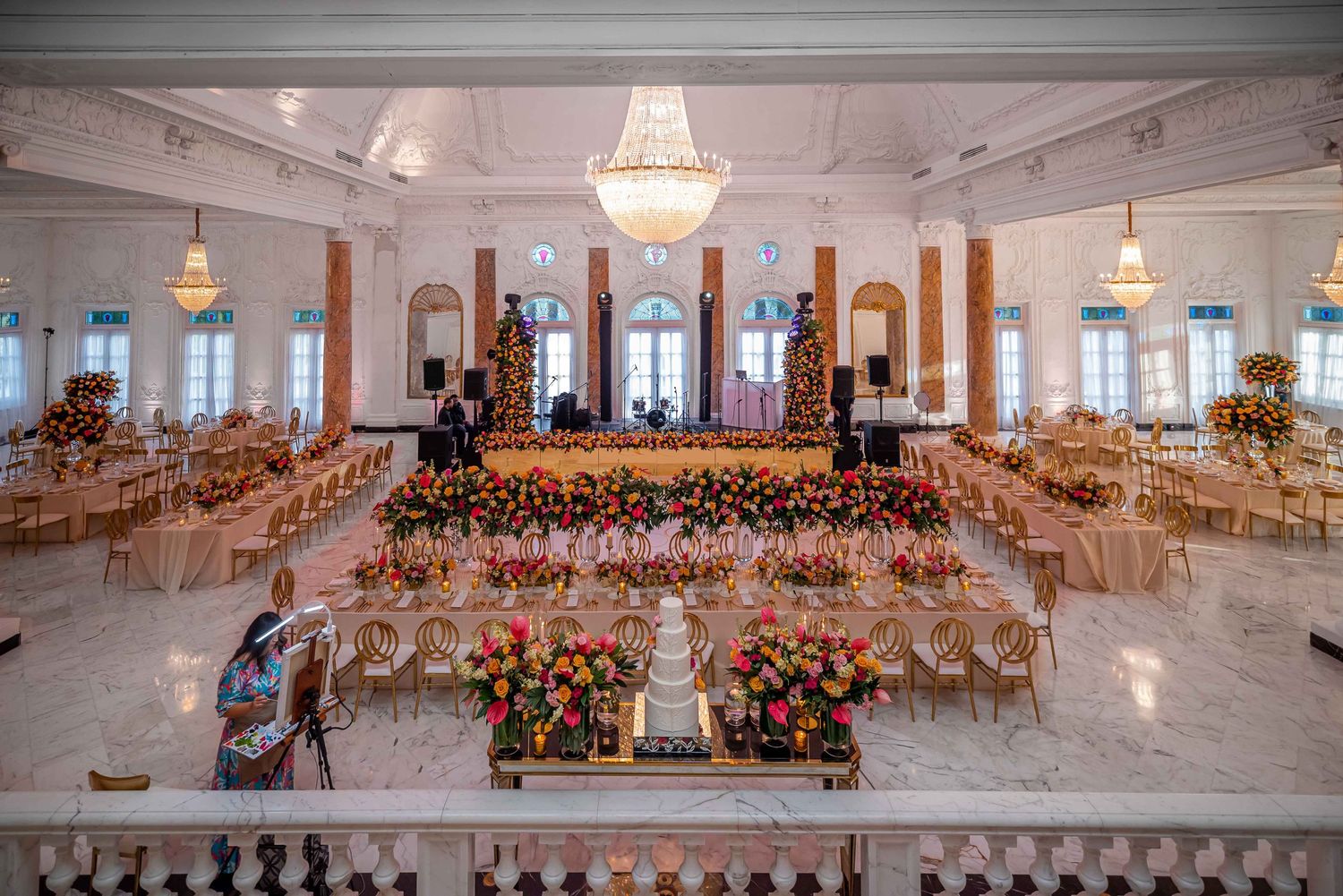 Luxurious ballroom wedding reception with crystal chandeliers and floral table arrangements.