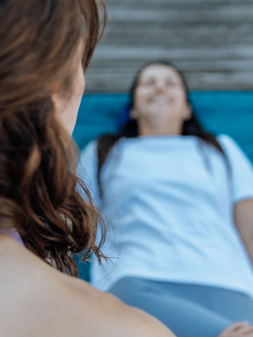 Patient lying on blue medical examination table during therapy or treatment session at a clinic.