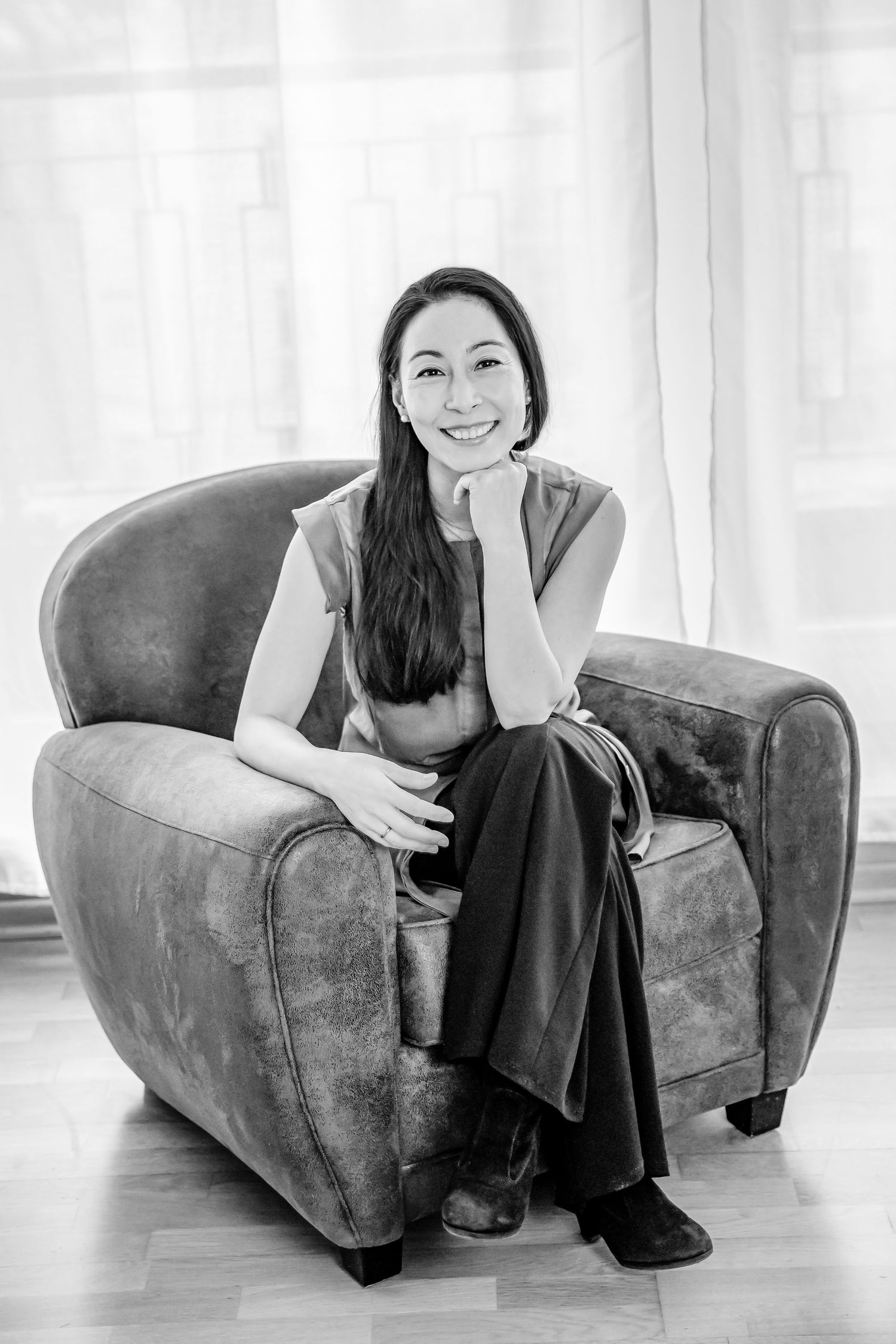 personal branding portrait of business woman Berlin seated in arm chair.