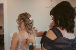 A quiet moment during wedding preparations as final touches are made to the bridal ensemble.