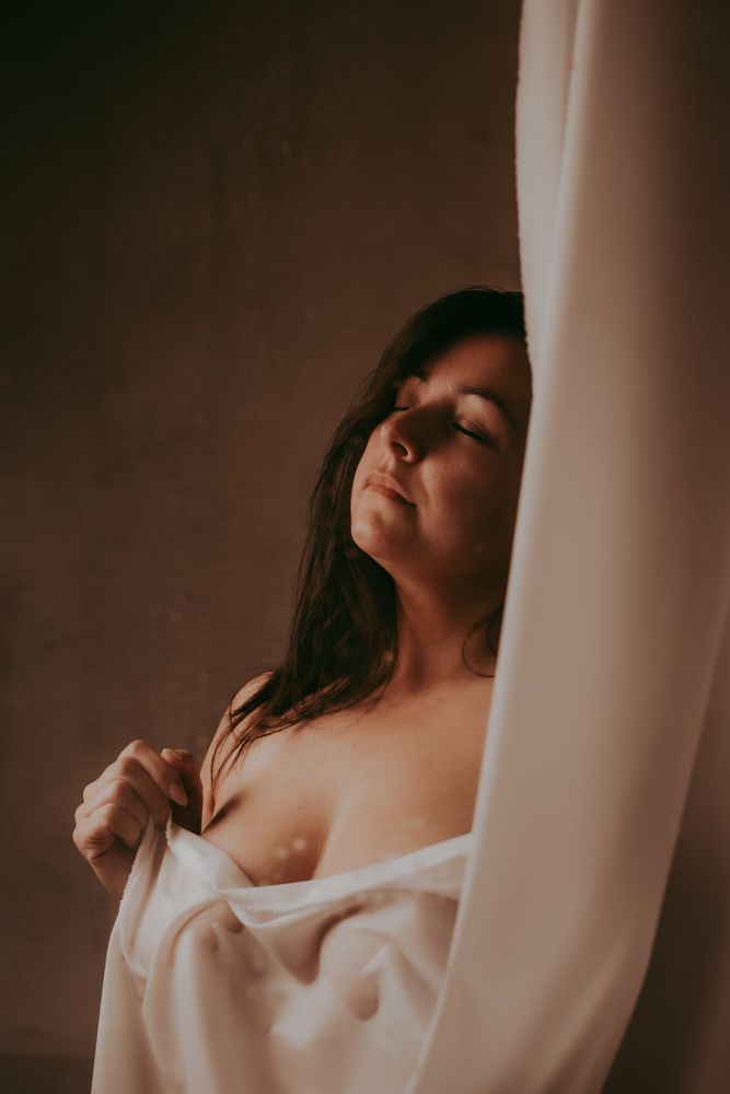 Sensuele foto van een vrouw met een doek voor haar lichaam in boudoir stijl