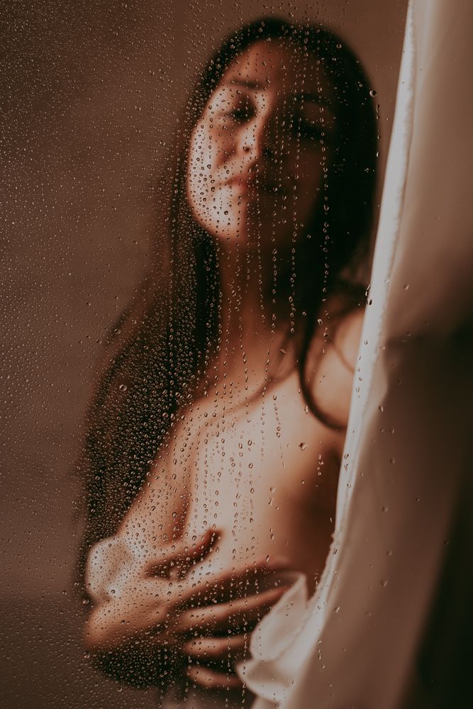 Gedrapeerd wit doek voor een vrouwenlichaam geposeerd voor een boudoir foto