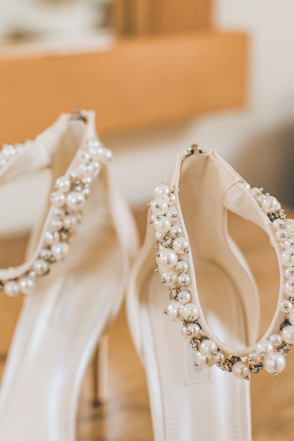 Delicate pearl-adorned white dress hangers lined up in a row.