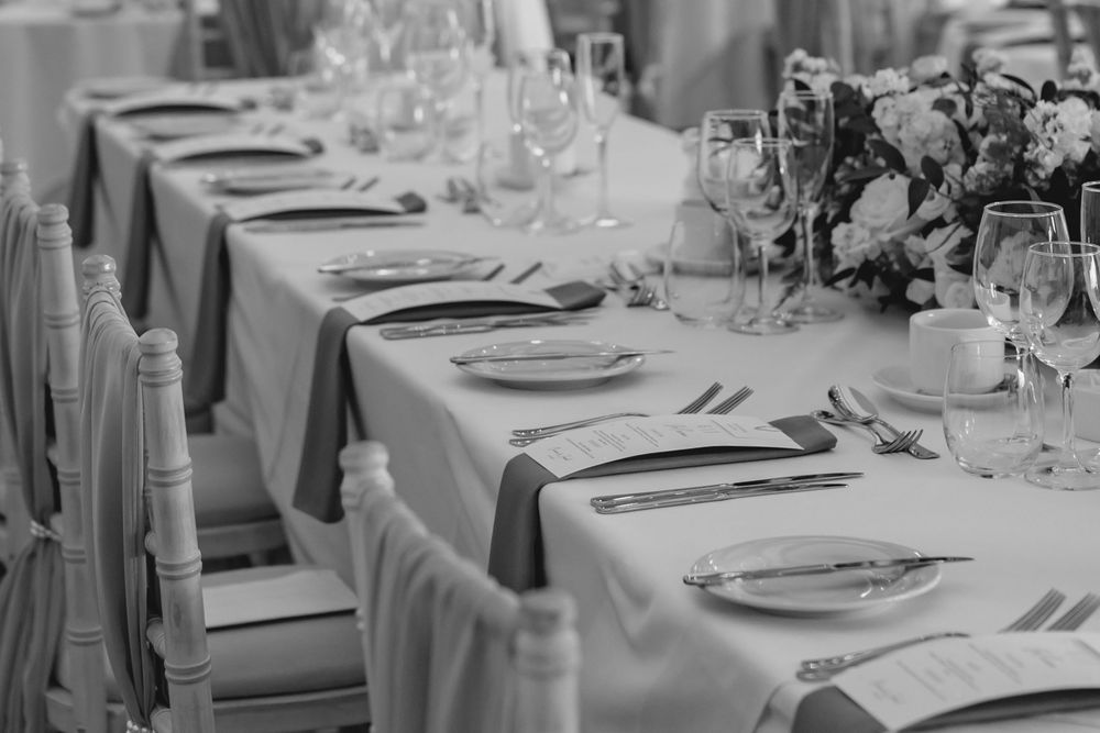 Elegant wedding table setting with formal place settings and floral centerpieces.