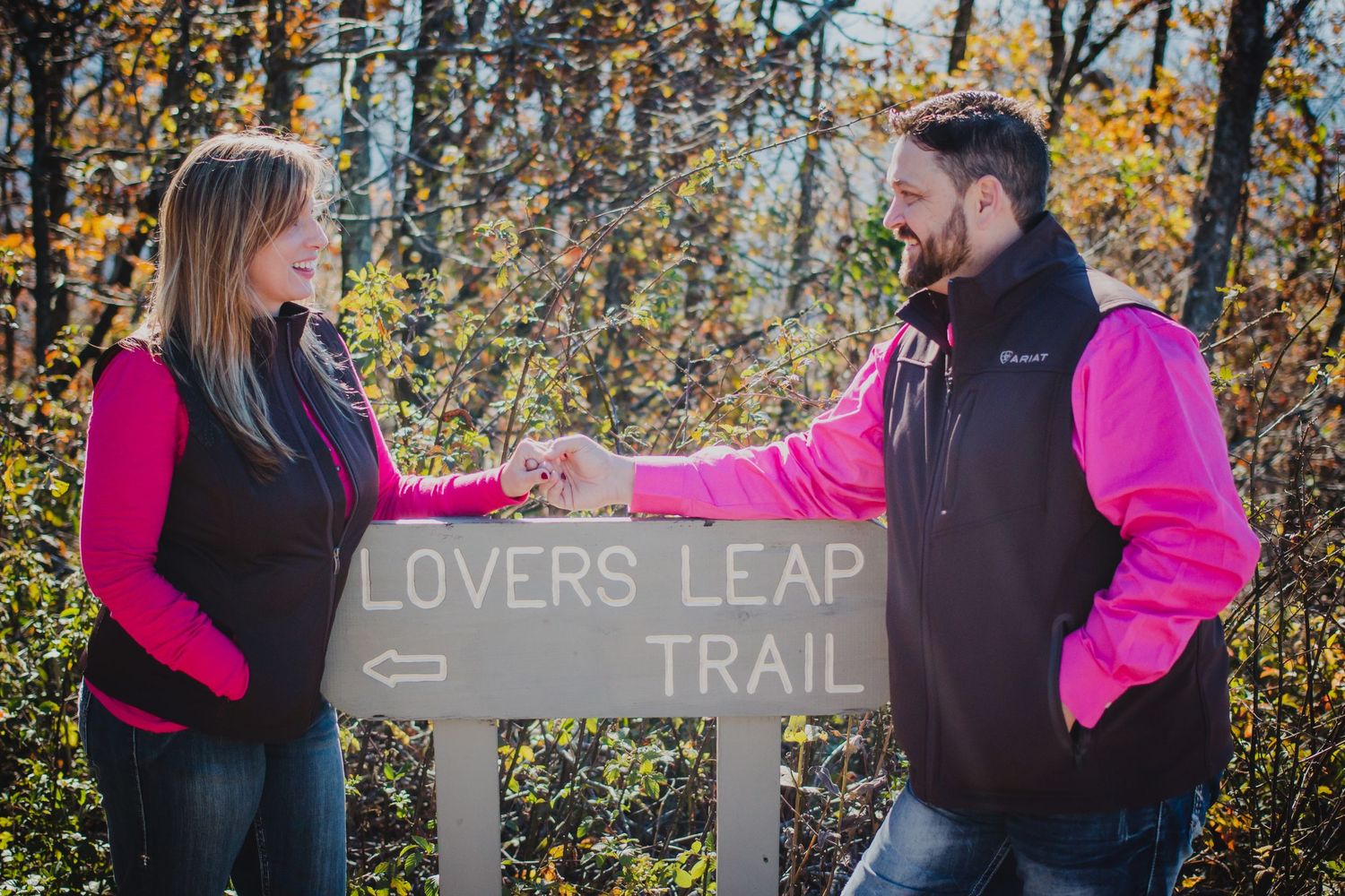 Larry and Misty holding hands at the Lovers Leap Trailhead in Arkansas. Adventure engagement session by Wolfpack Wedding Co.