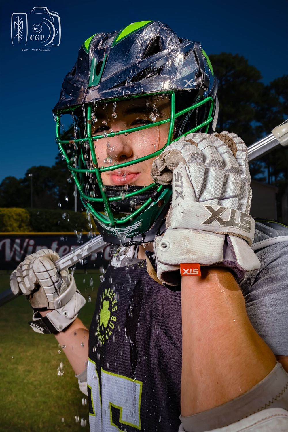 Lacrosse player in green helmet and white gloves shown in multiple action poses against blurred outdoor background.
