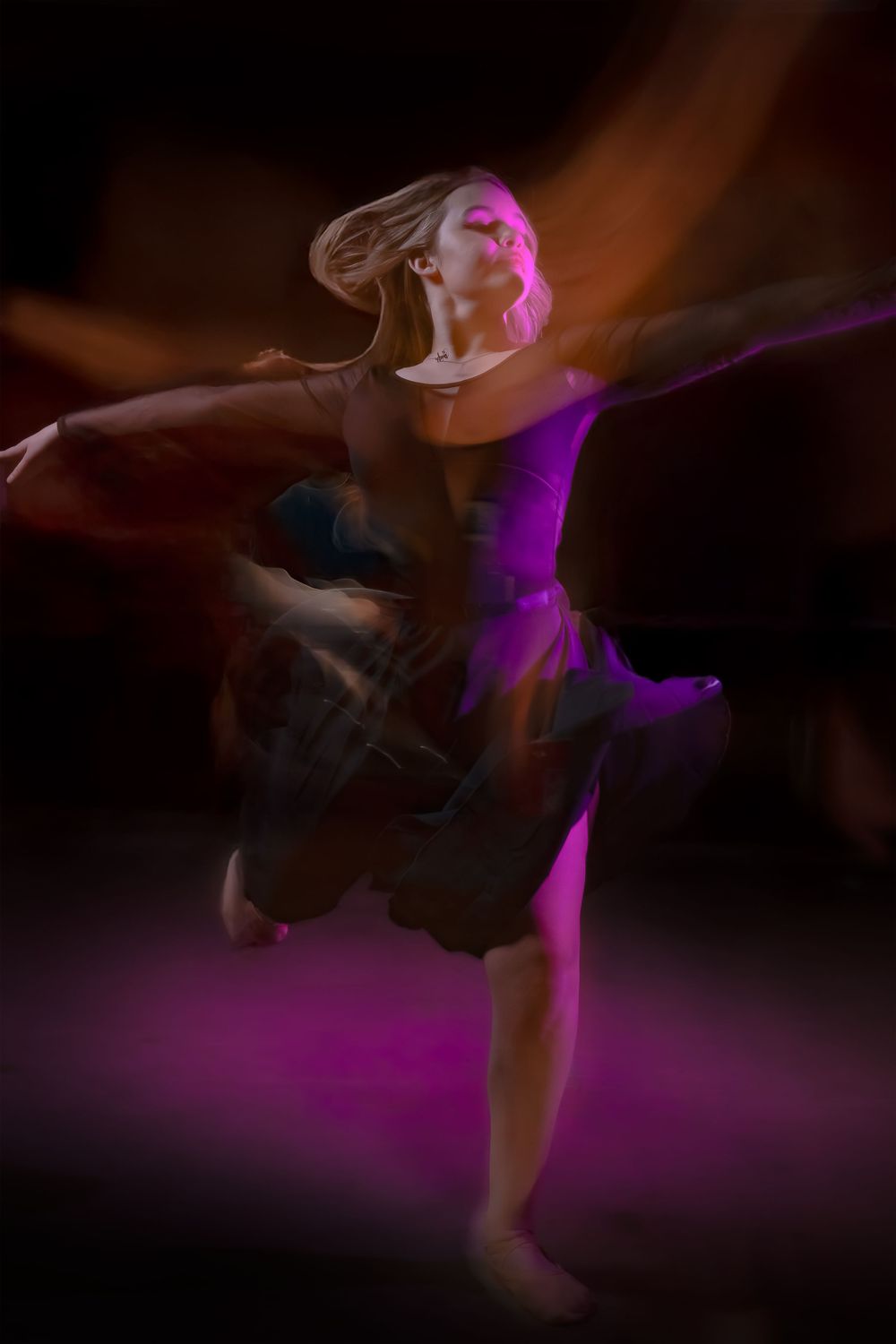 A dancer in motion captured with motion blur effect under dramatic purple lighting on dark background.