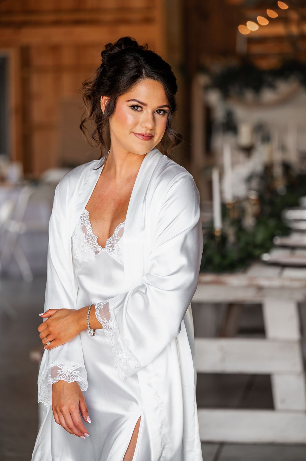White silk bridal robe with lace trim in rustic barn setting.