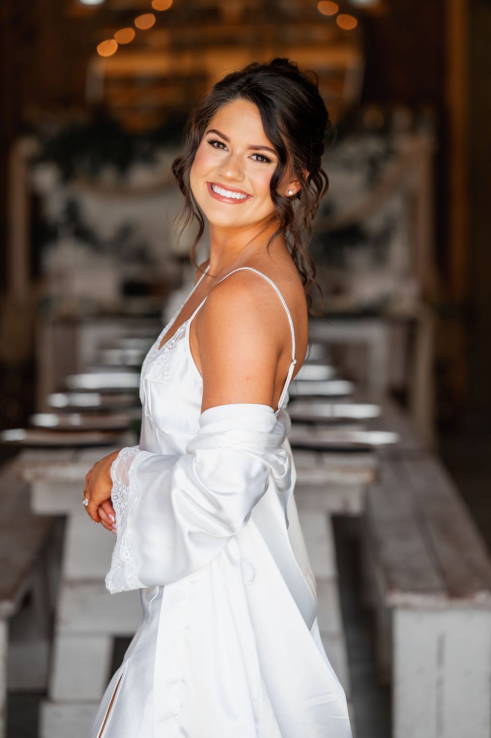 White bridal getting ready attire in rustic barn venue.