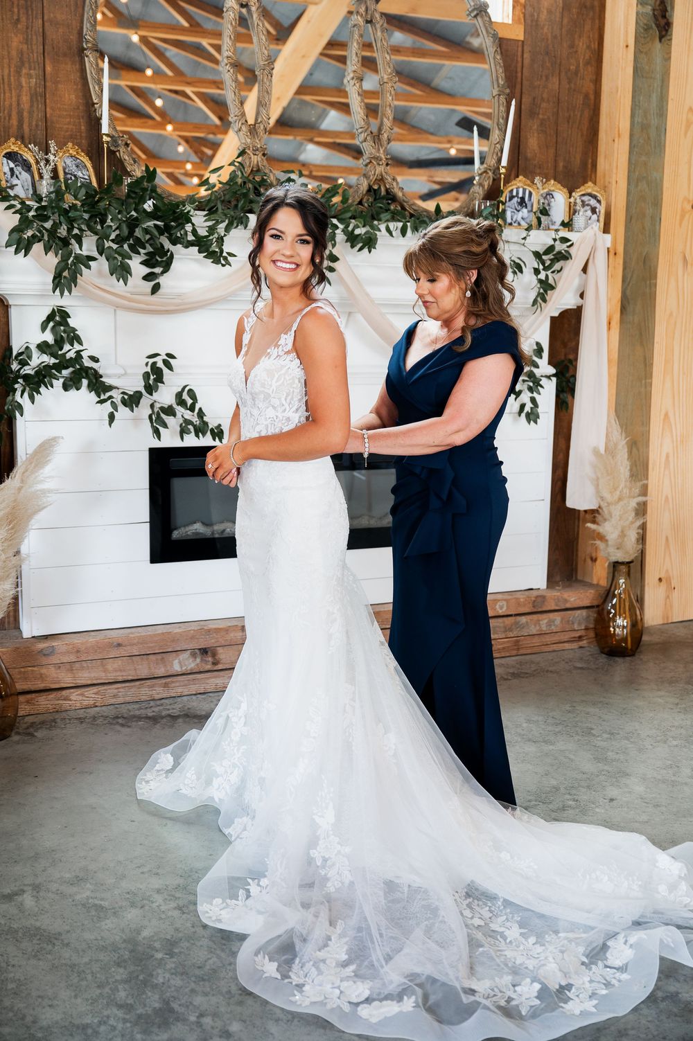 Beautiful lace wedding dress with long train in rustic venue setting.