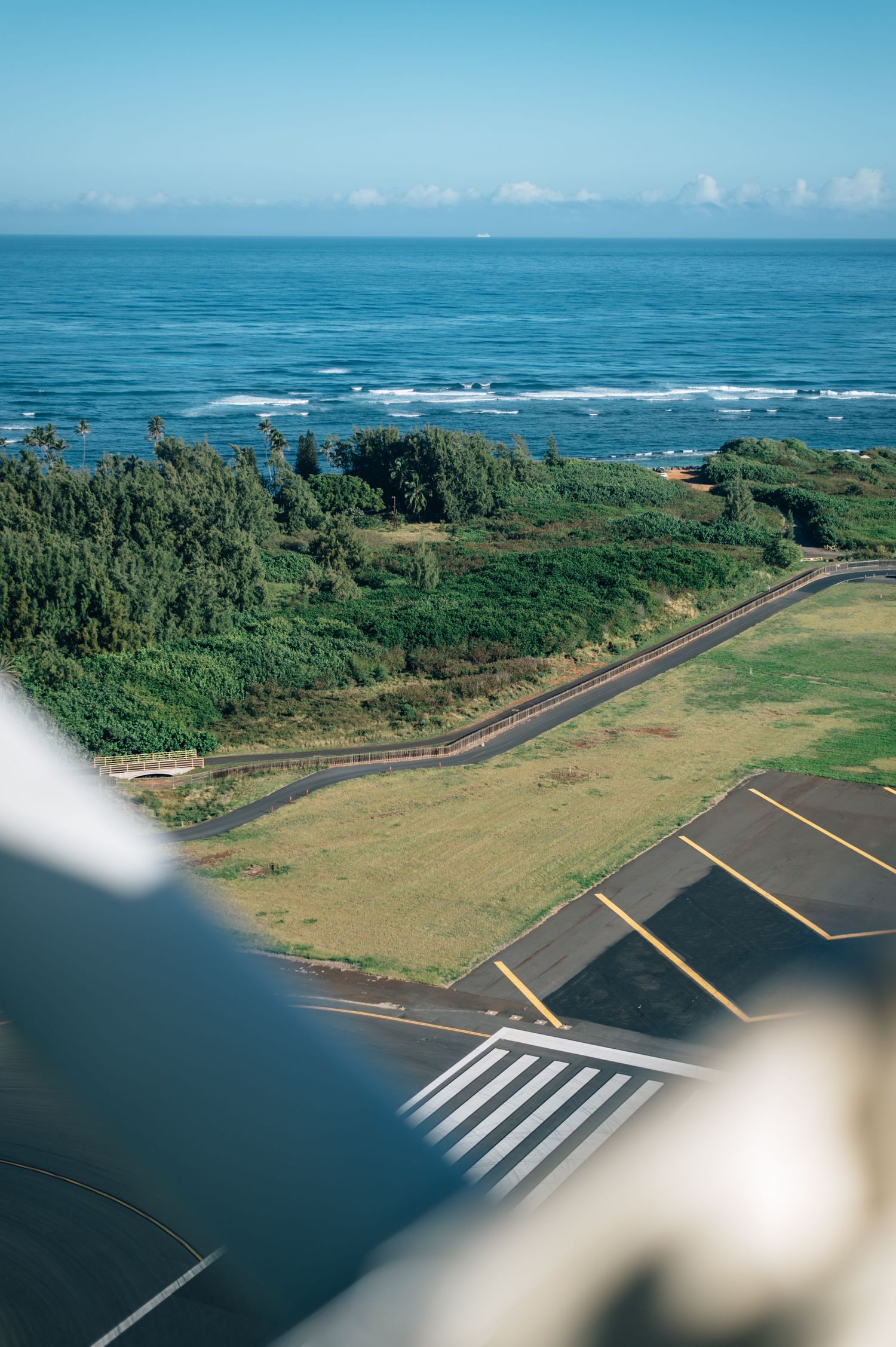 Aerial view of a coastal runway surrounded by lush vegetation and ocean.