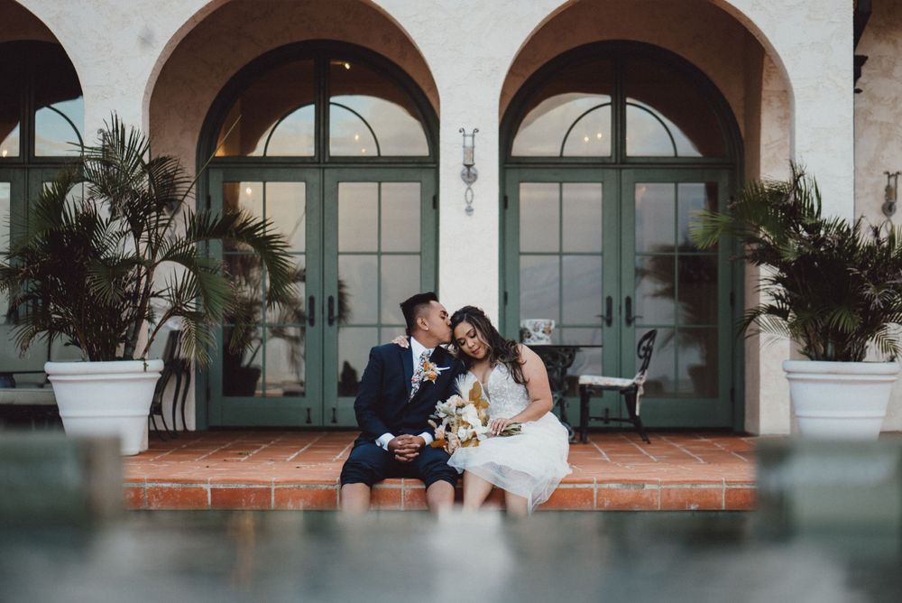 Wedding ceremony setting with elegant arched windows and Mediterranean architectural details.