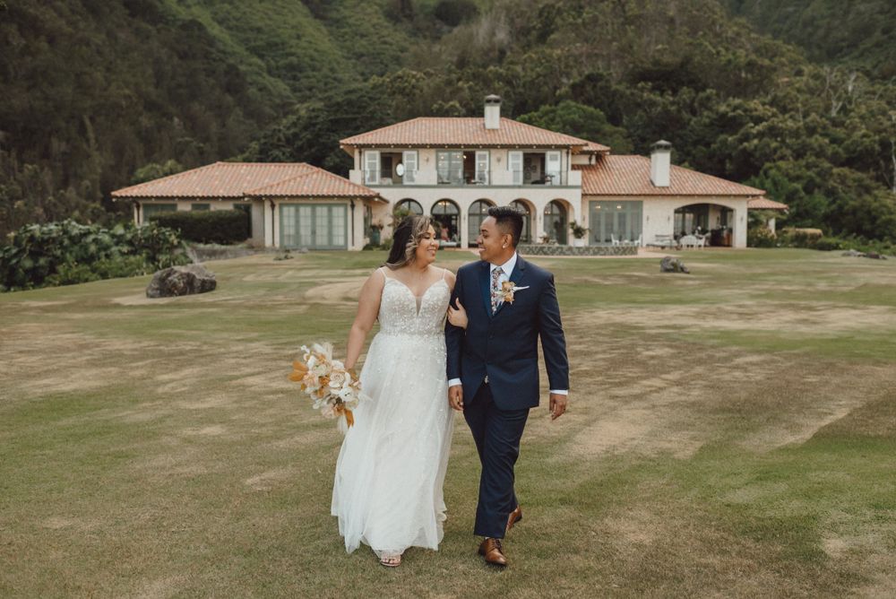 Scenic wedding venue with Spanish-style architecture nestled in lush green hillside.