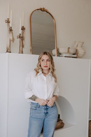 Lifestyle photography session with decorative mirror and wall sconces in background.