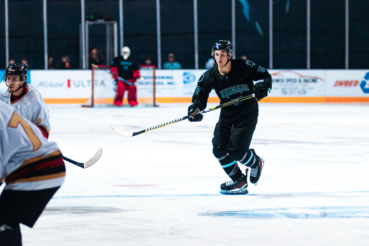 Hockey players on an ice rink practicing drills during a training session.