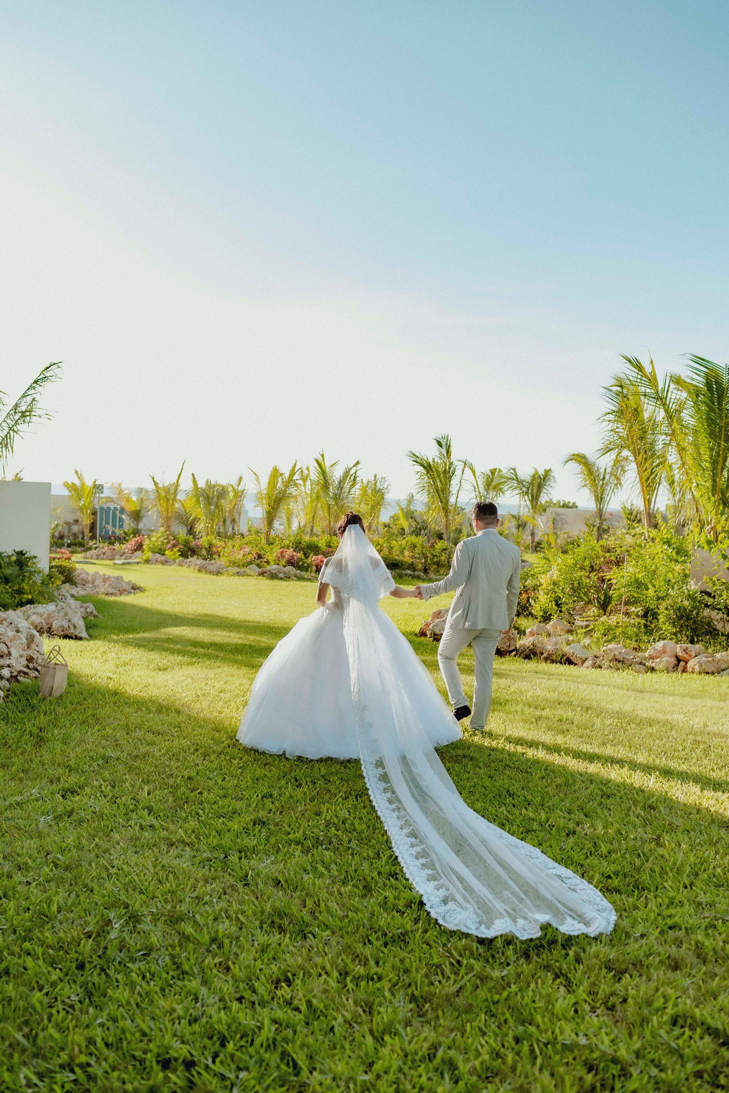 Bride and groom walking barefoot on a white sand beach in Zanzibar at sunset