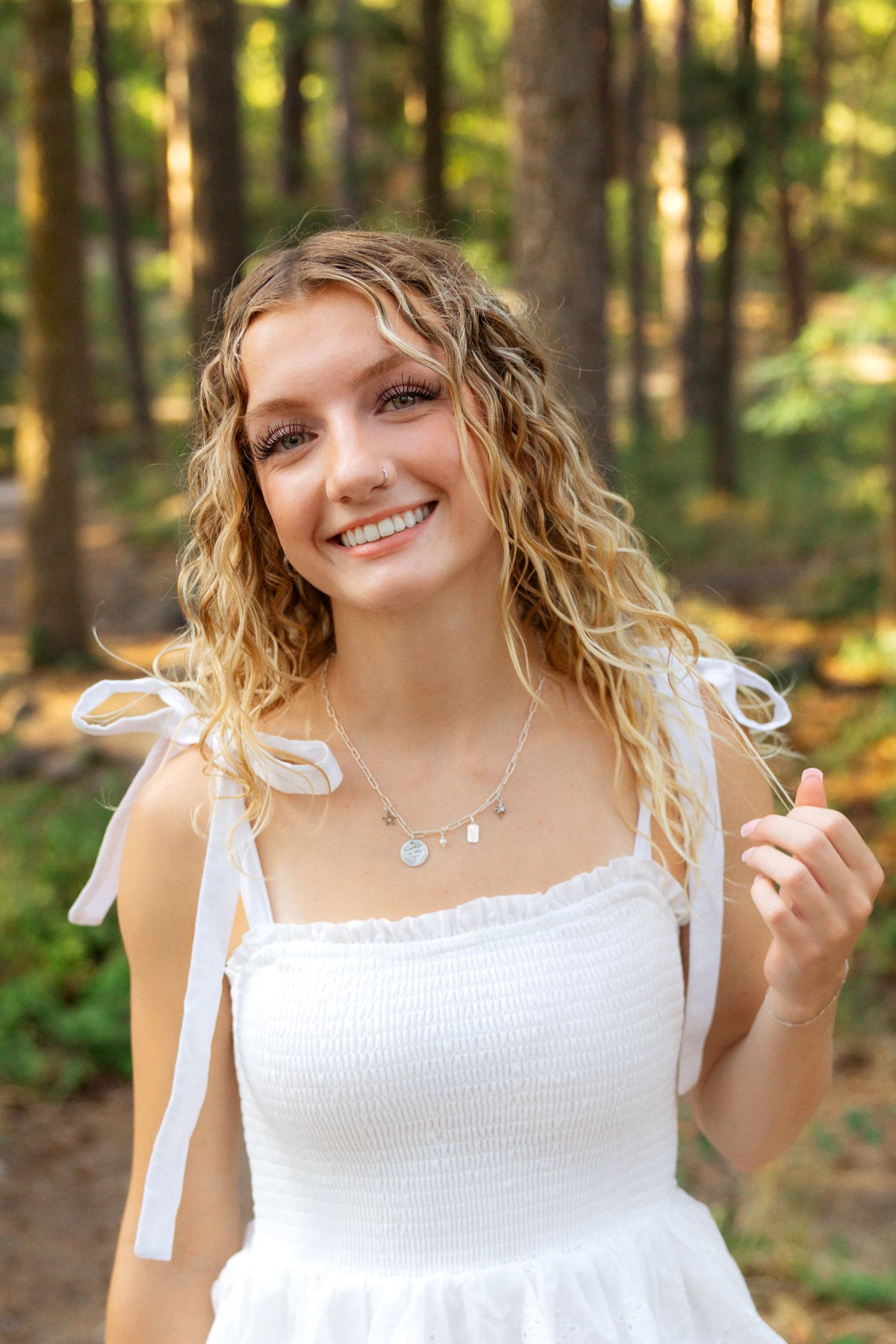 A series of photos showing a person in a white smocked sundress posing playfully against a sunlit forest background.
