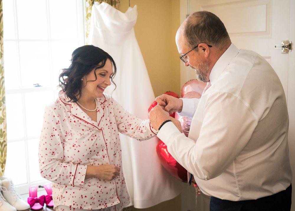 Wedding preparation sequence showing final touches being made to bridal attire in a warm-lit room.