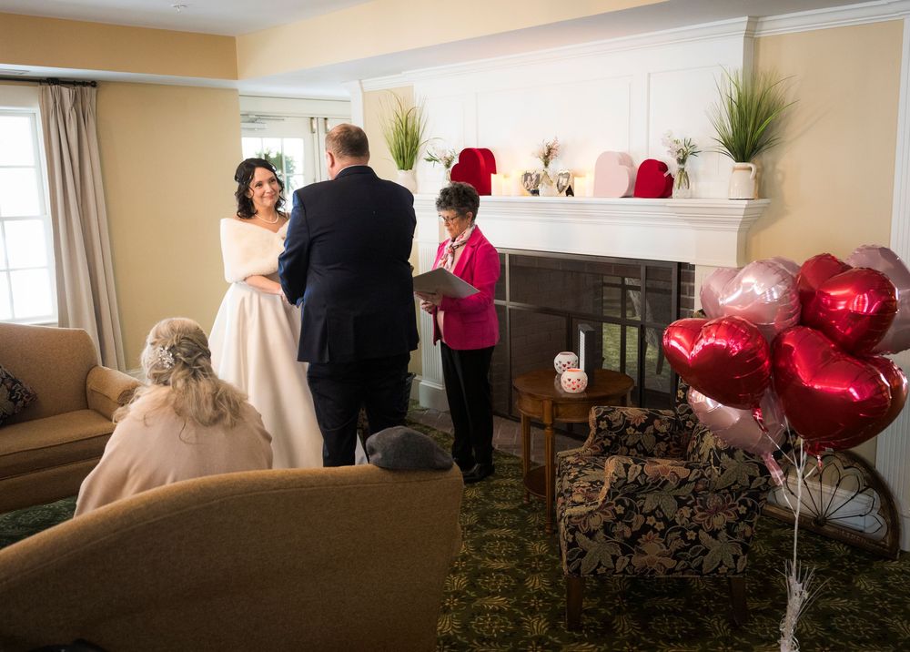 Wedding preparation scene in a room with red decor elements and natural lighting.