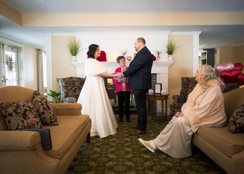 Wedding party gathered in an elegant room with beige carpeting and comfortable seating.
