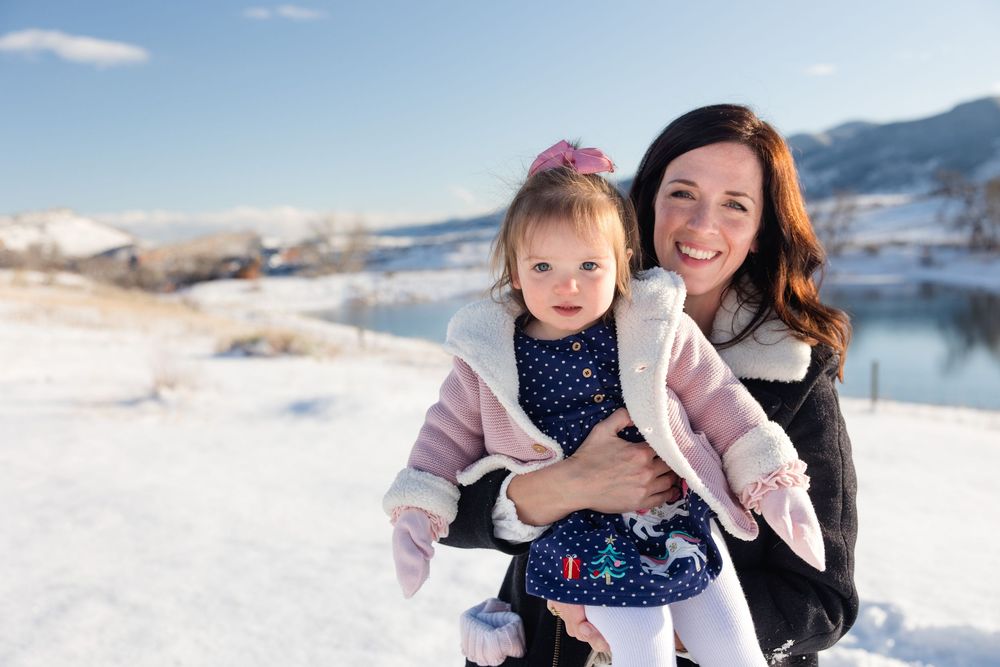 Family enjoying a winter day together in the snowy mountains during golden hour.
