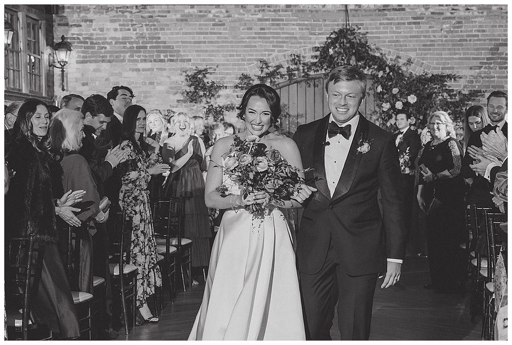 A series of black and white wedding celebration photos showing joyful moments and dancing at an indoor reception venue.