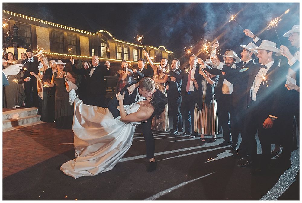Wedding celebration on outdoor patio at night with string lights illuminating dancing guests.