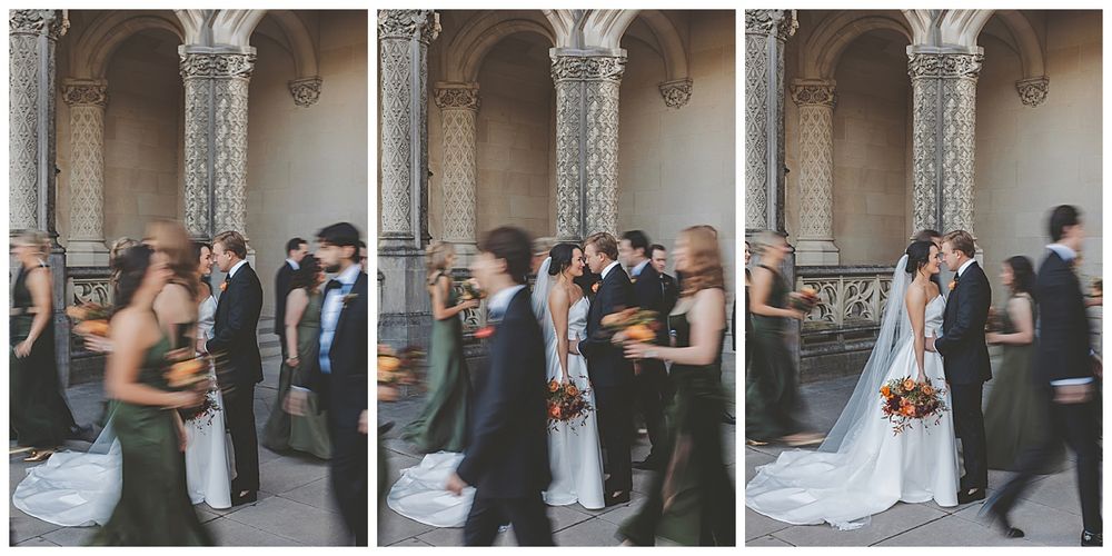 Wedding party gathered under decorative stone archways and columns for formal group portraits.