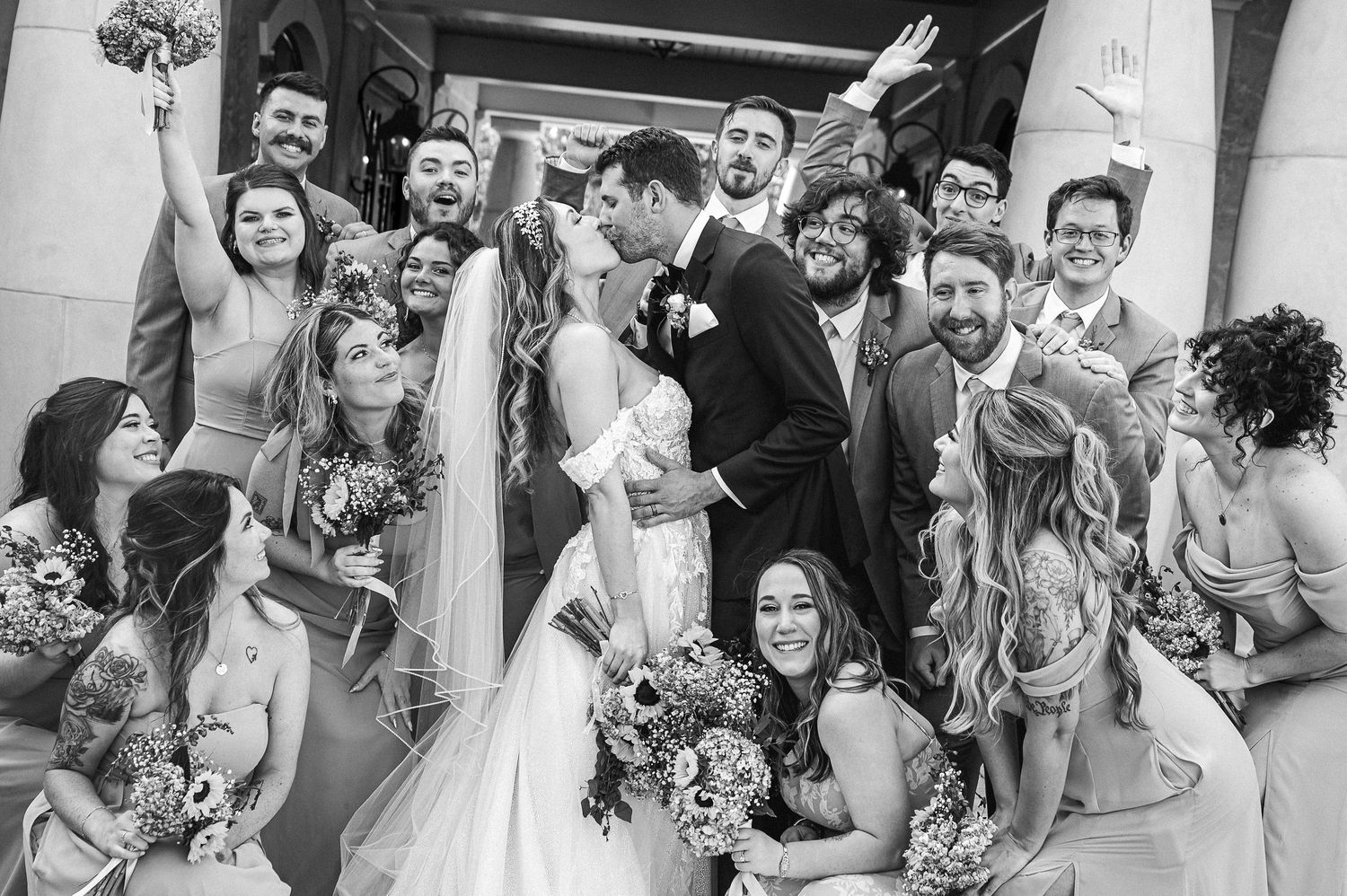 Wedding guests celebrate and cheer during an outdoor reception.