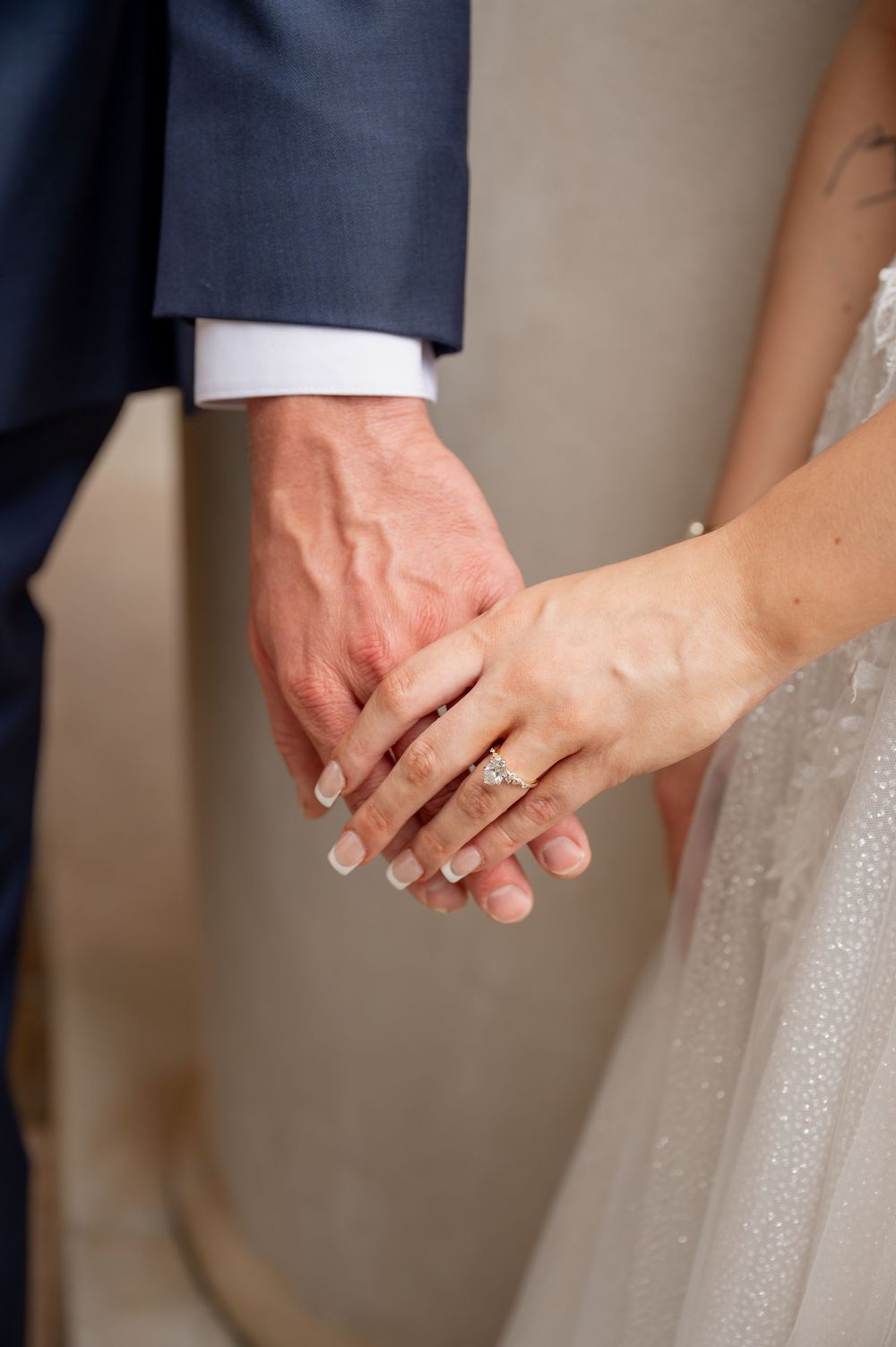 Close-up of hands showing wedding rings during an intimate ceremony moment.