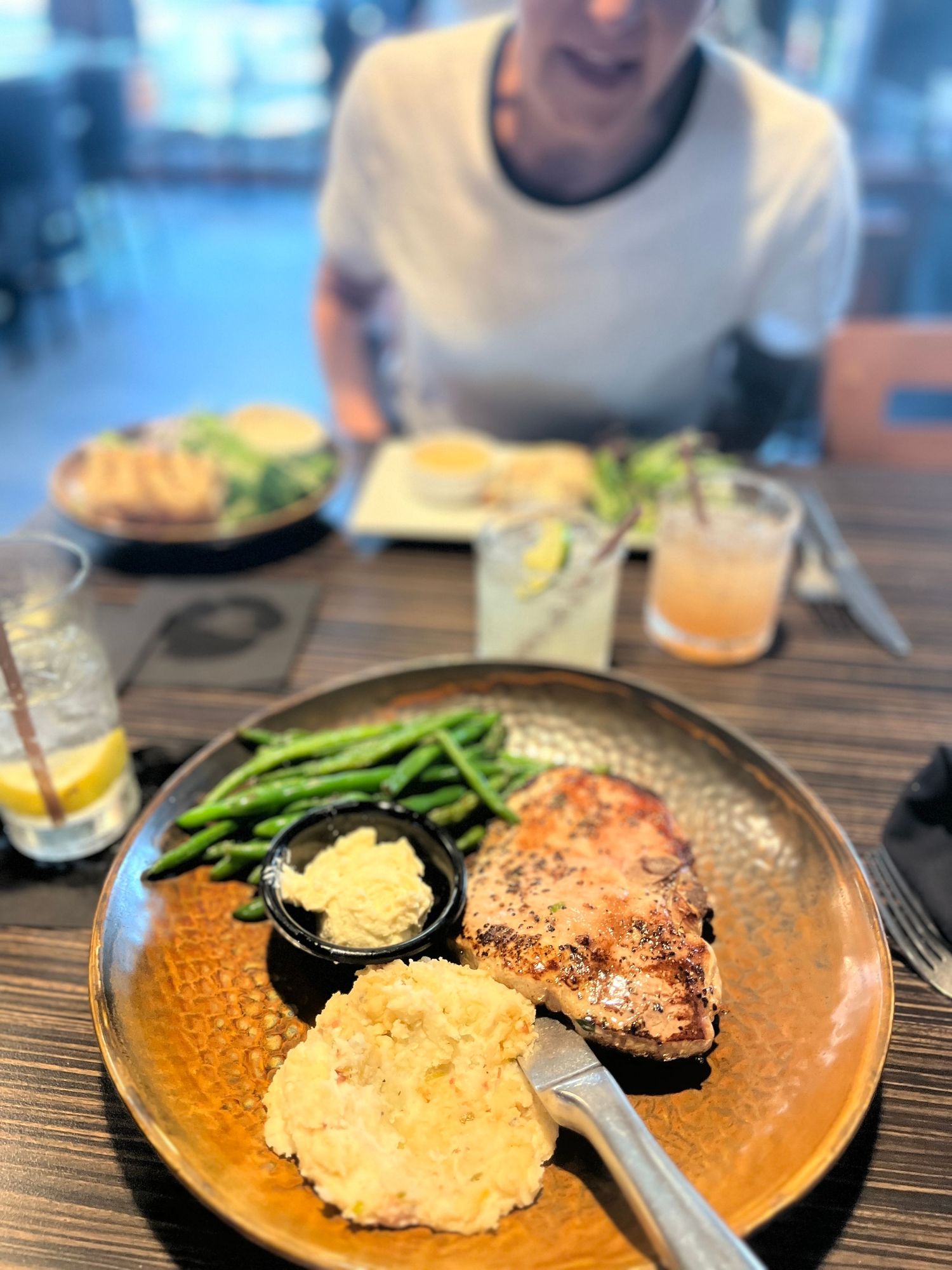 A plated dinner featuring grilled salmon with asparagus and a creamy rice pilaf on a textured ceramic dish.
