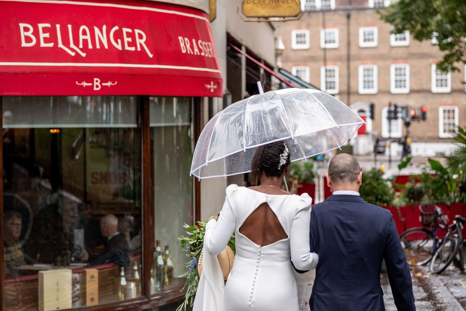 A London wedding couple walks past a restaurant.