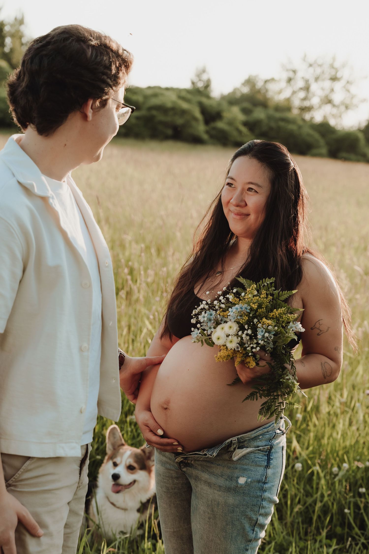 Photo de maternité avec des fleurs et un chien.