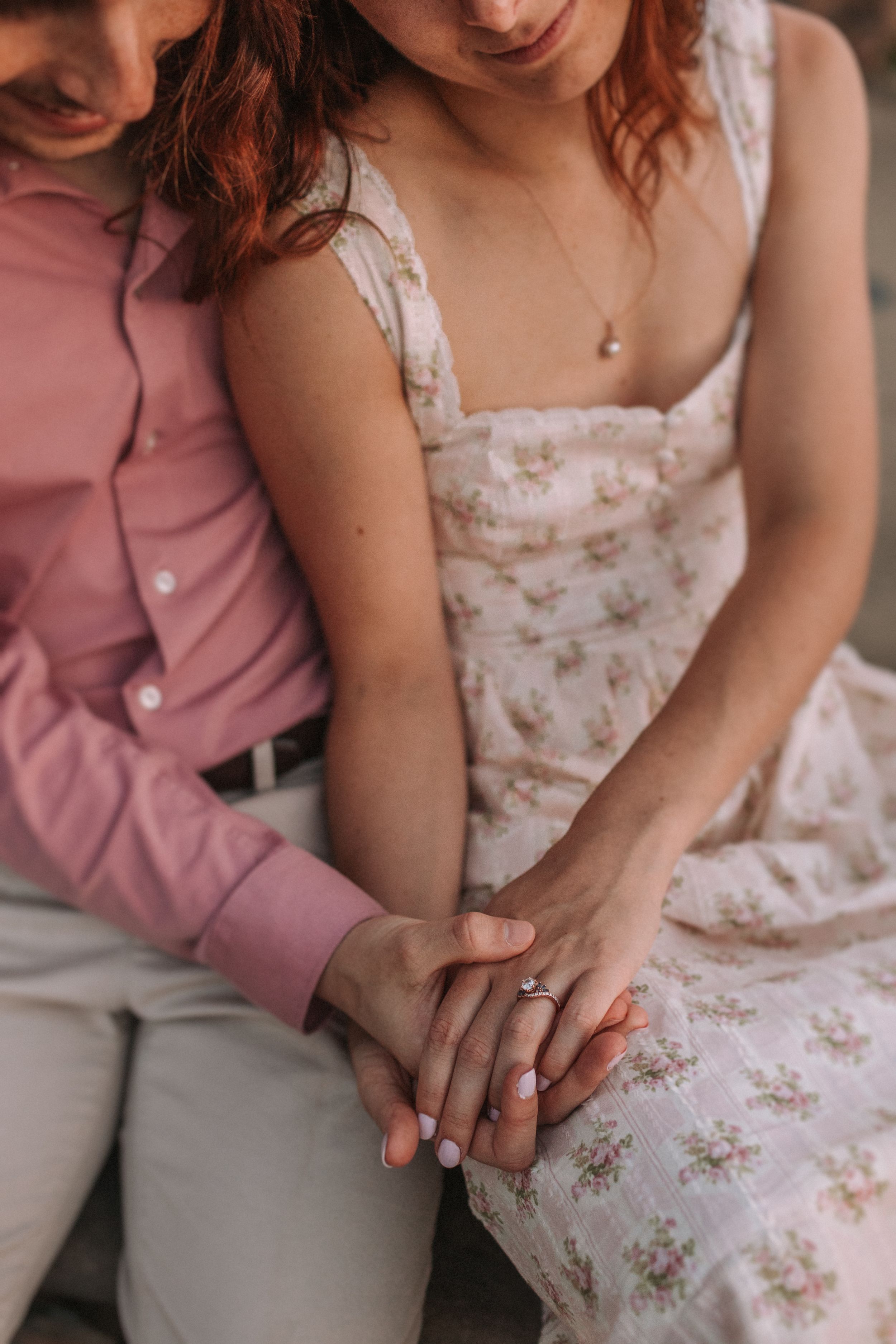 Close-up sequence of hands gently resting on a floral dress and light colored pants.
