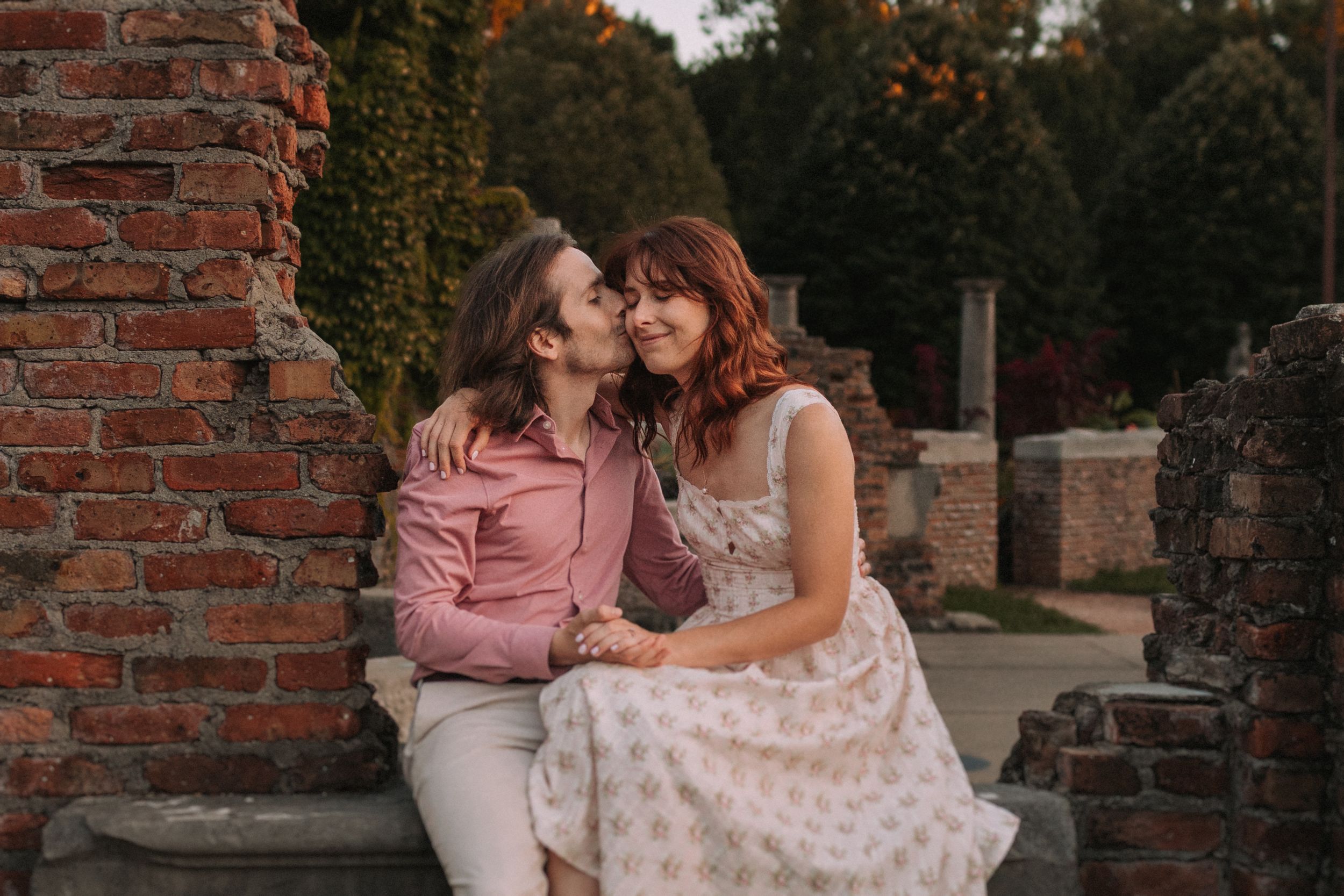 A tender moment shared between a couple sitting on historic brick ruins.