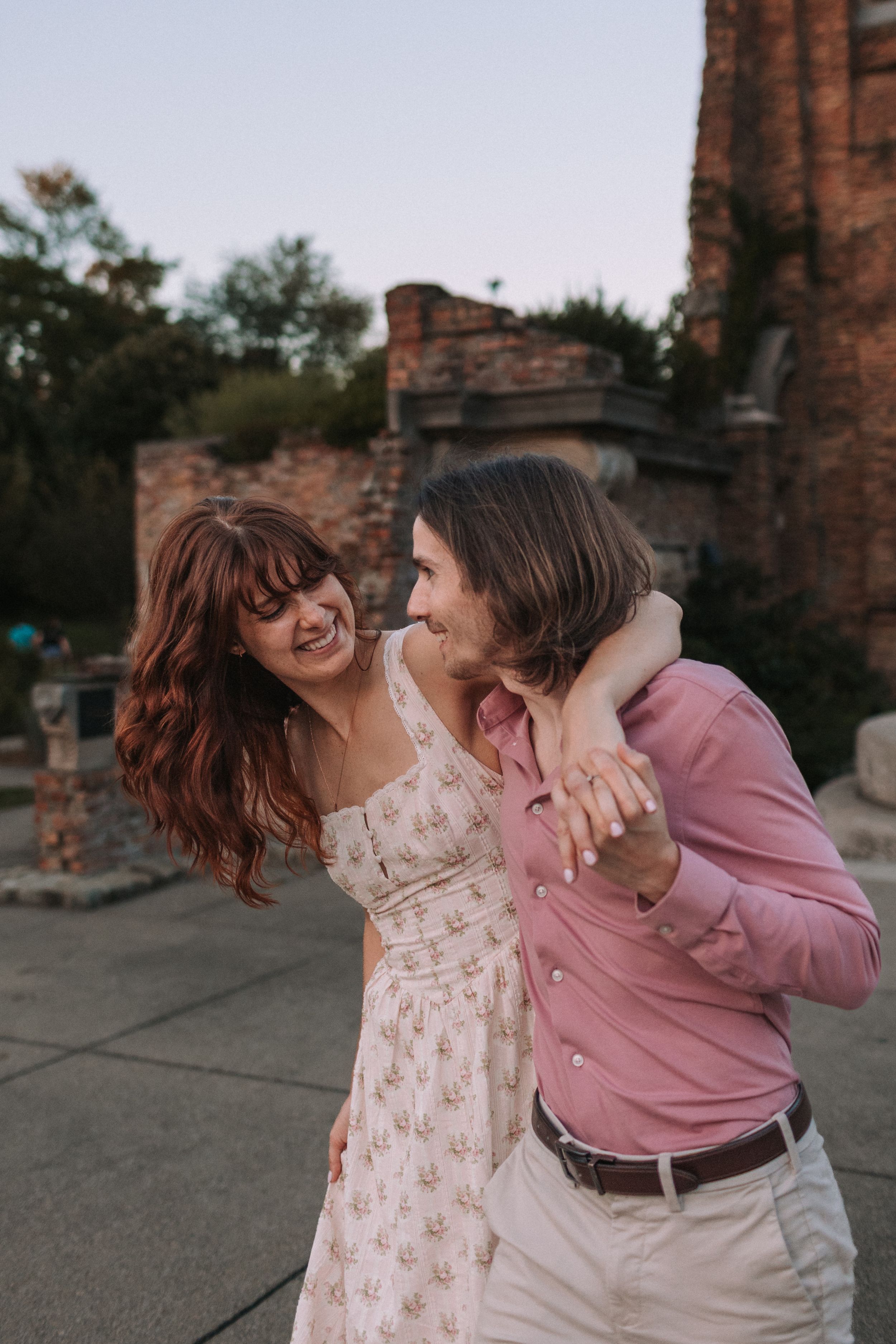 A playful dancing moment captured between a couple near historic ruins.