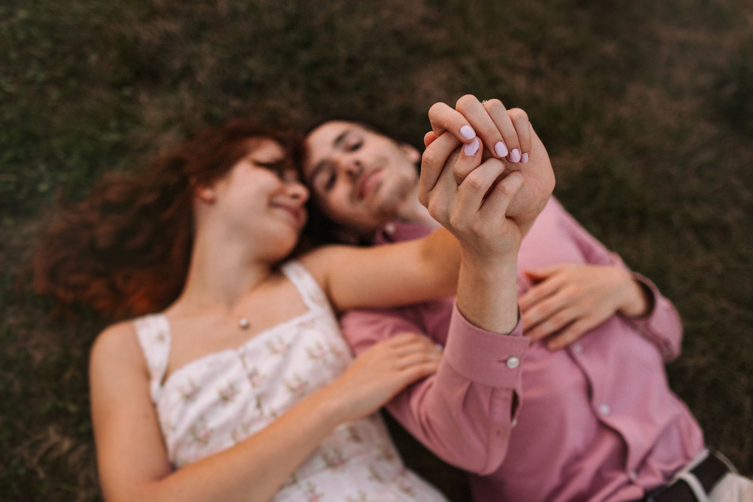 A romantic couple embraces tenderly during an outdoor photo session in a natural setting.