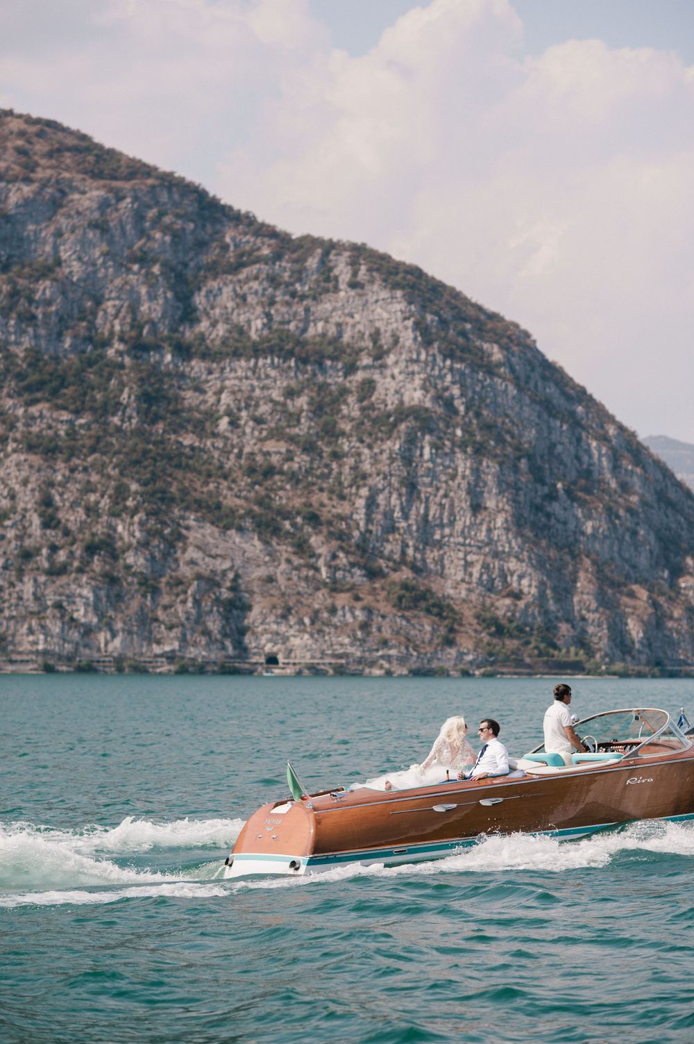Elegant arrival of the couple by Riva boat at their destination wedding on Lake Iseo
