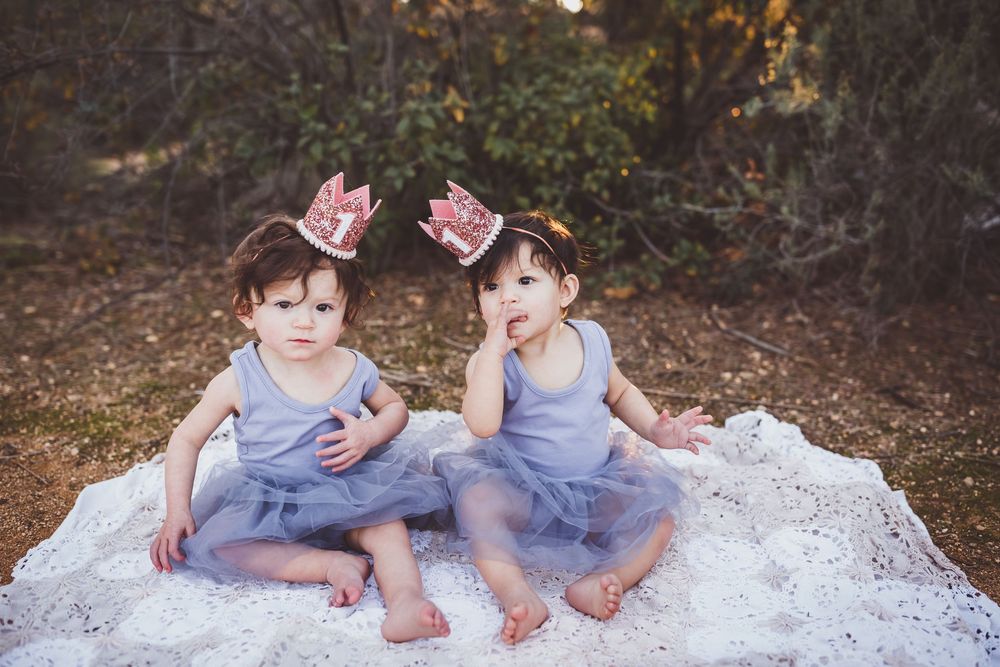 Children playing and having fun on a white blanket surrounded by autumn foliage.
