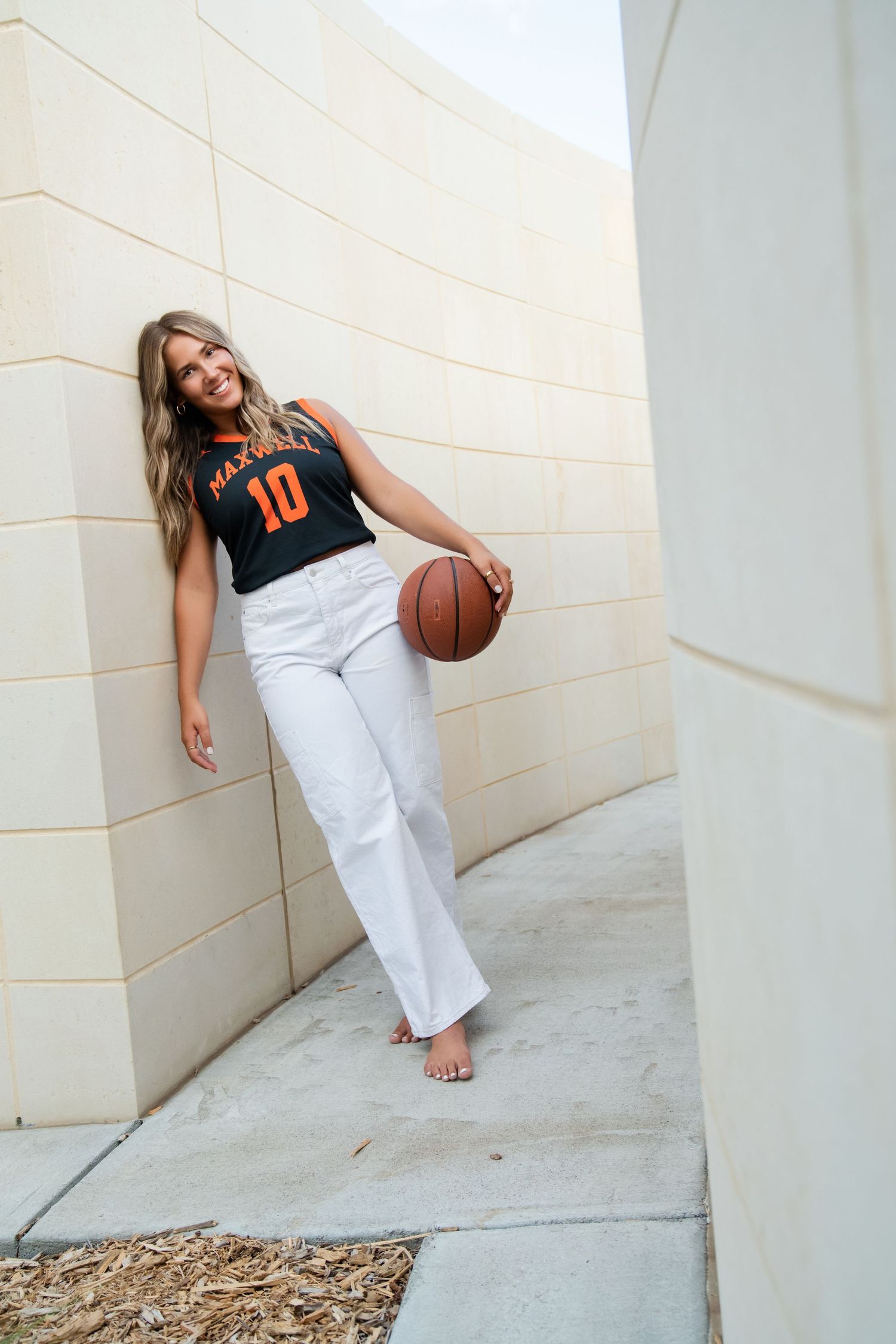 Three casual lifestyle photos showing someone in a black jersey and white pants posing against a light colored wall with a basketball.