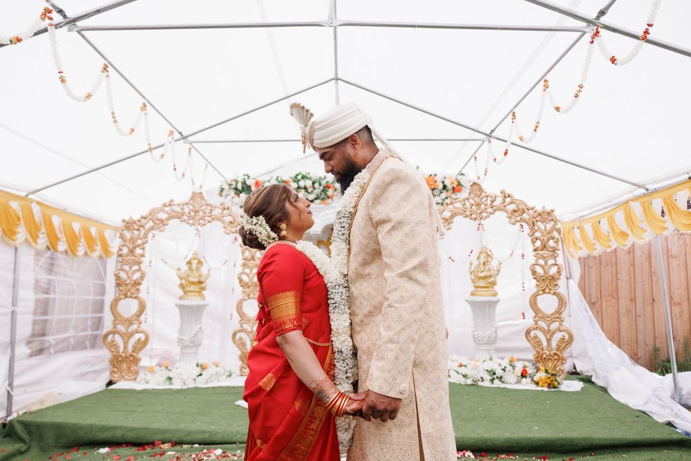 Wedding ceremony setup with white tent and gold decorative elements under string lights.